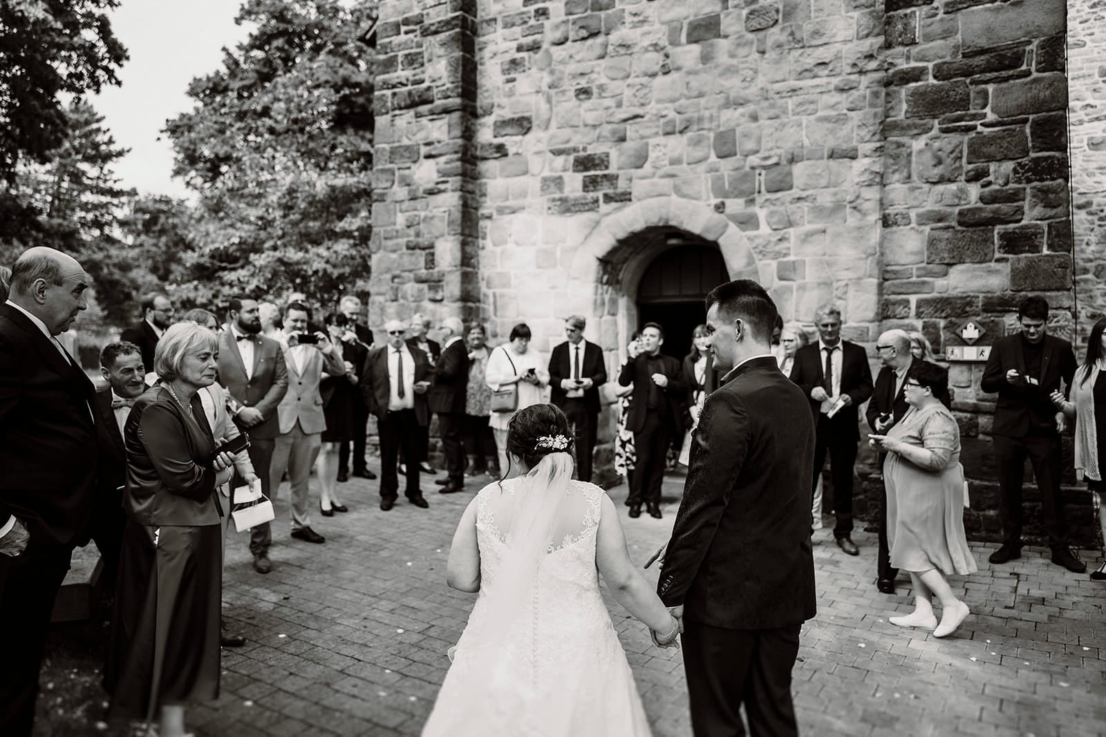 Stiepeler Dorfkirche Landhaus Grum Hattingen Hochzeitsfotograf - Hochzeitsgäste versammeln sich nach Trauung vor der Dorfkirche