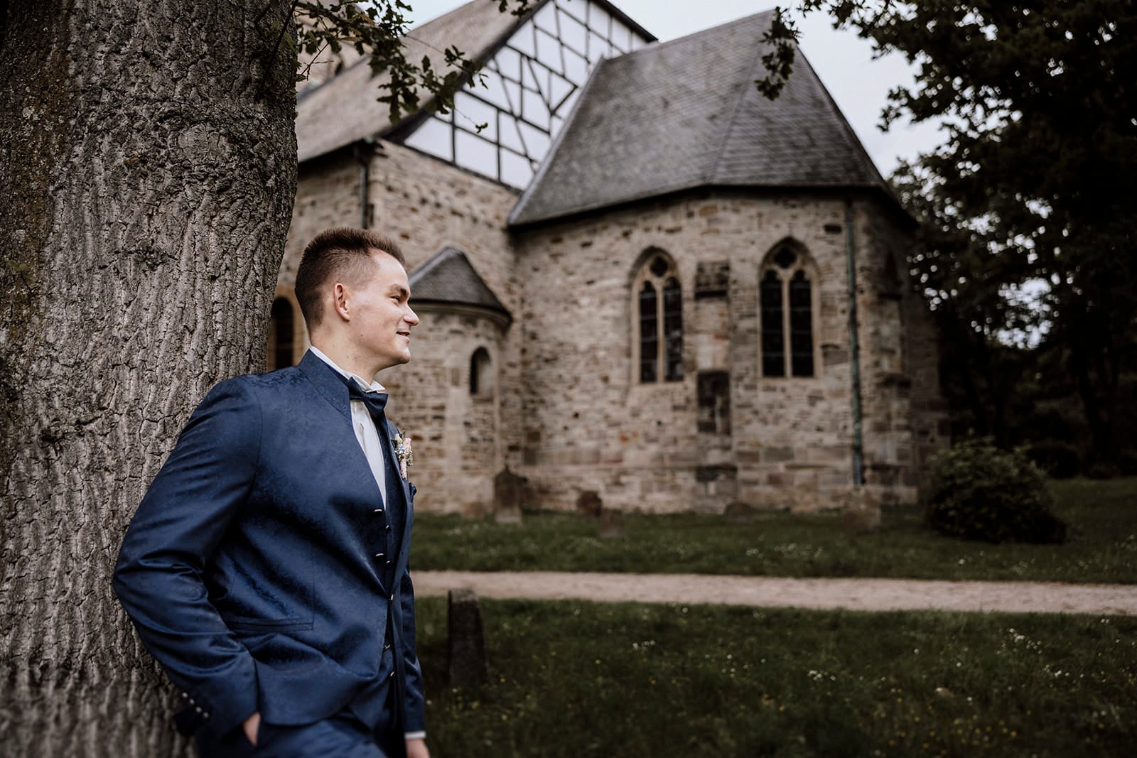 Stiepeler Dorfkirche Landhaus Grum Hattingen Hochzeitsfotograf - Bräutigam steht vor der Stiepeler Dorfkirche