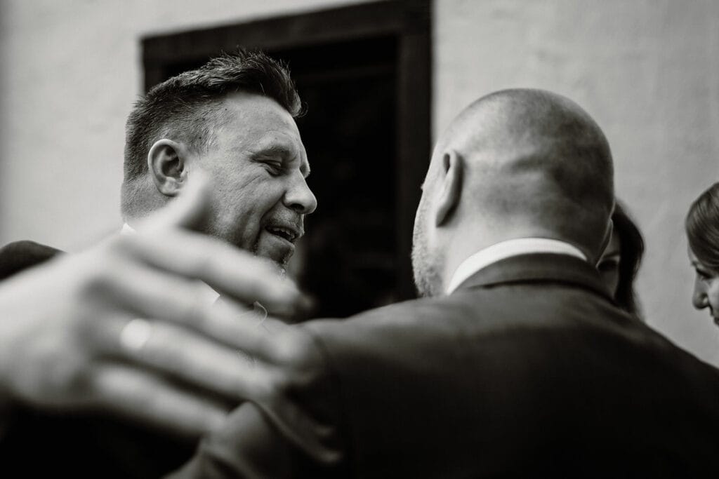 Glessener Mühlenhof Bergheim Hochzeitsfotograf - Trauzeuge umarmt Bräutigam