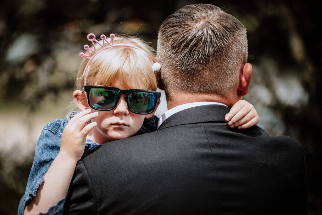 Glessener Mühlenhof Bergheim Hochzeitsfotograf - Kind mit Sonnenbrille Hochzeitsgast schaut in die Kamera
