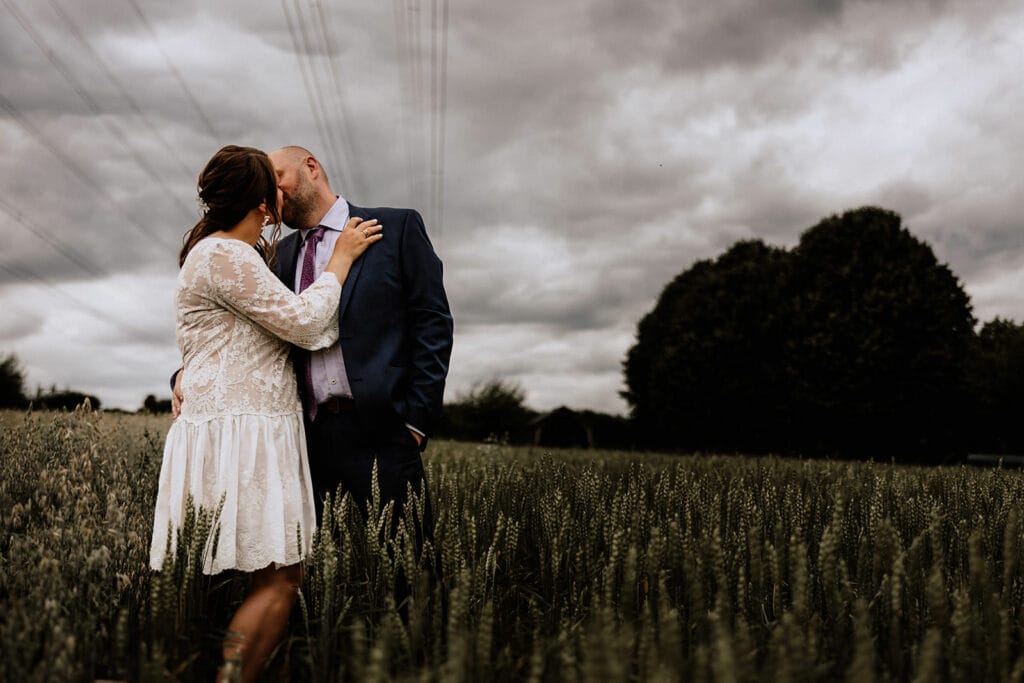 Glessener Mühlenhof Bergheim Hochzeitsfotograf - Braut und Bräutigam küsst sich auf Maisfeld