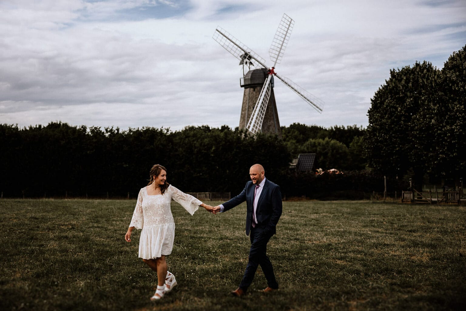 Glessener Mühlenhof Bergheim Hochzeitsfotograf - Brautpaar läuft vor Glessener Mühle entlang