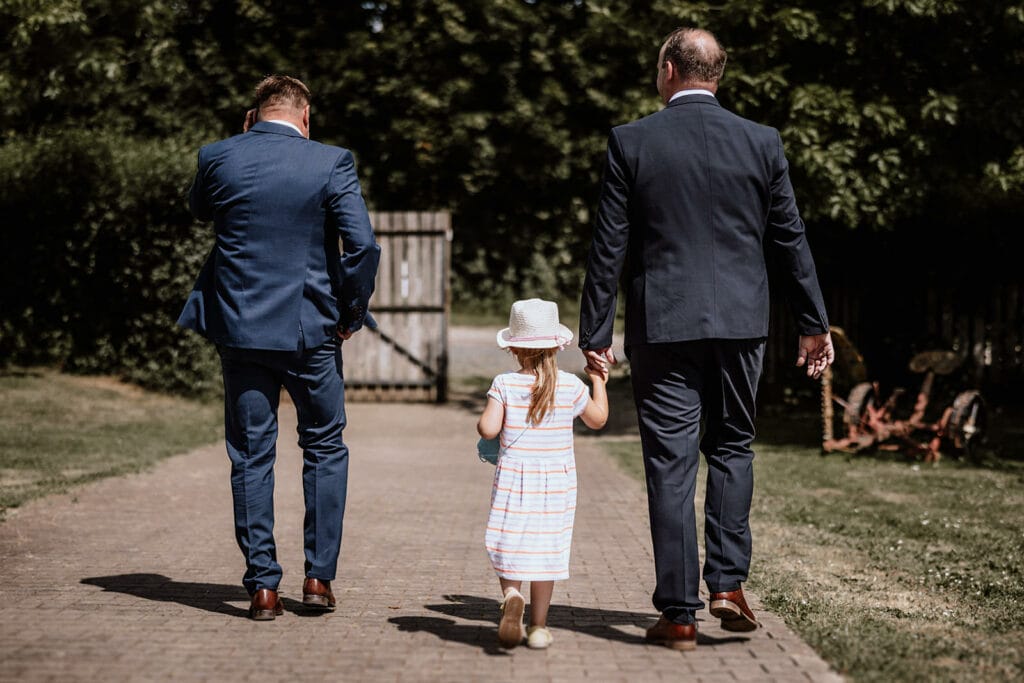 Glessener Mühlenhof Bergheim Hochzeitsfotograf - Trauzeugen laufen mit Kind beim Mühlenhof entlang