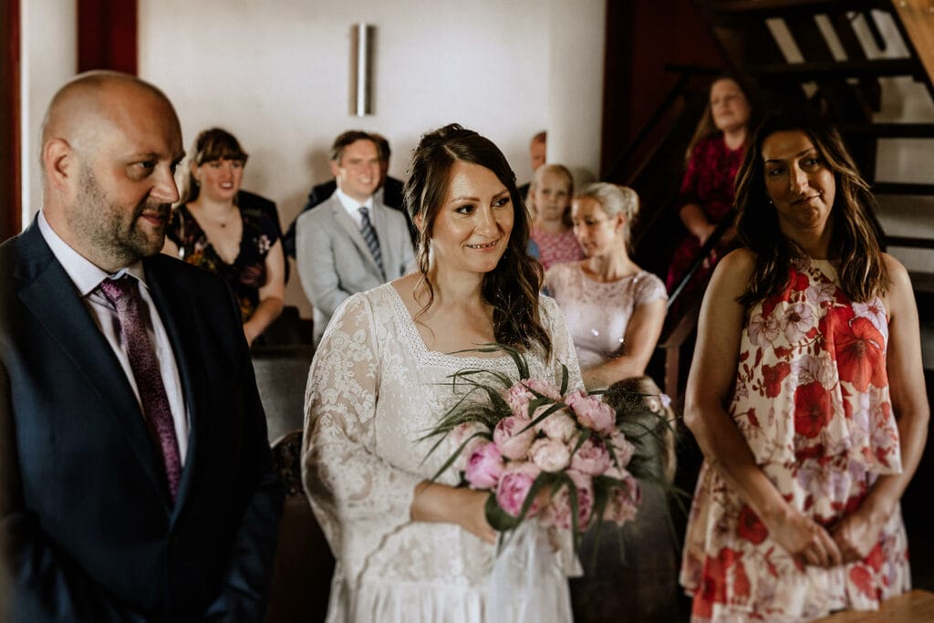 Glessener Mühlenhof Bergheim Hochzeitsfotograf - Braut hält Blumenstrauß zur Trauung