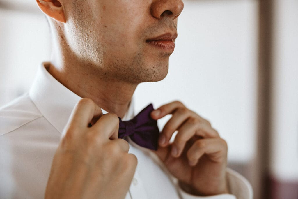 Herrenhaus Cromford Ratingen 25hours Hotel Düsseldorf Hochzeitsfotograf - Bräutigam richtet seine Fliege beim Getting Ready zurecht