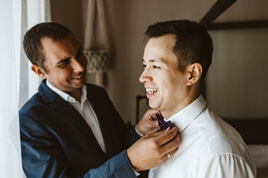 Herrenhaus Cromford Ratingen 25hours Hotel Düsseldorf Hochzeitsfotograf - Trauzeuge hilft Bräutigam bei Fliege