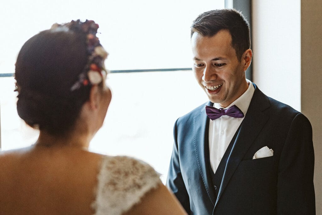 Herrenhaus Cromford Ratingen 25hours Hotel Düsseldorf Hochzeitsfotograf - Bräutigam bewundert Braut First Look