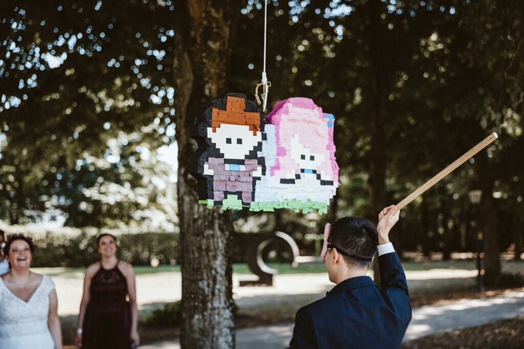 Herrenhaus Cromford Ratingen 25hours Hotel Düsseldorf Hochzeitsfotograf - Piñata Bräutigam schlägt mit Holzstock ein