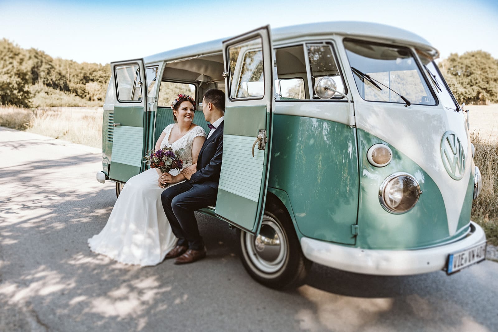 Herrenhaus Cromford Ratingen 25hours Hotel Düsseldorf Hochzeitsfotograf - Hochzeitspaar sitzt beim VW Bulli heraus