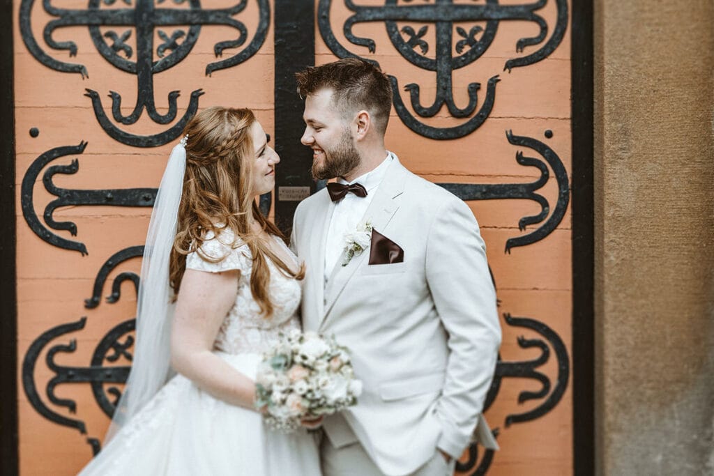 St. Lambertus Mettmann Trüffelschwein Hilden Hochzeitsfotograf - Braut und Bräutigam vor Kirchentor