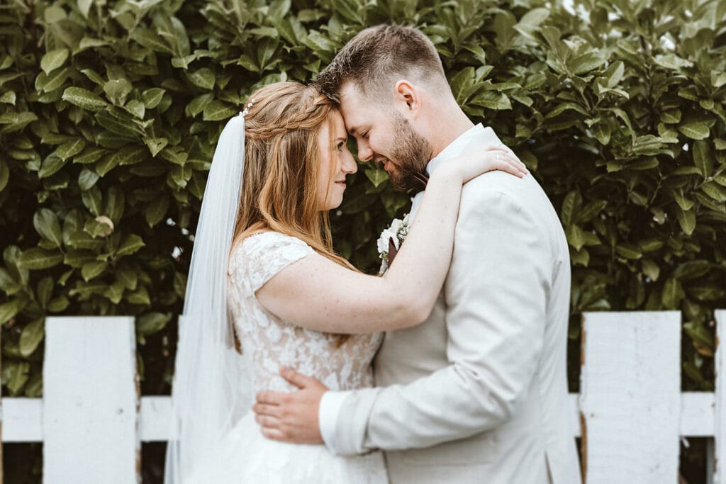 St. Lambertus Mettmann Trüffelschwein Hilden Hochzeitsfotograf - Bräutigam und Braut lehnen Stirn aneinander und umarmen sich