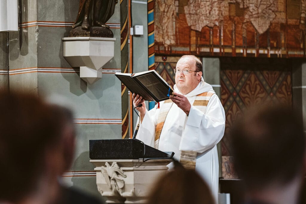 St. Lambertus Mettmann Trüffelschwein Hilden Hochzeitsfotograf - Priester liest aus Bibel in der Kirche vor