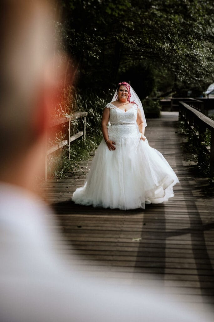 Schloss Oberhausen Empfang Nappenfeld Hochzeitsfotograf - Braut steht auf Holzbrücke und schaut Bräutigam an