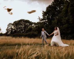 Schloss Oberhausen Empfang Nappenfeld Hochzeitsfotograf - Brautpaar bei Sonnenuntergang laufen Hand in Hand über Feld