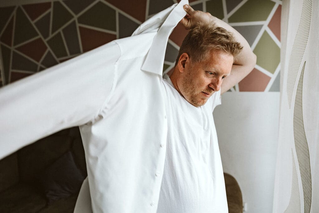 Schlosskapelle Diersfordt Wesel Schloss Diersfordt Wesel Hochzeitsfotograf - Bräutigam macht sich fertig zieht Hemd an Getting Ready