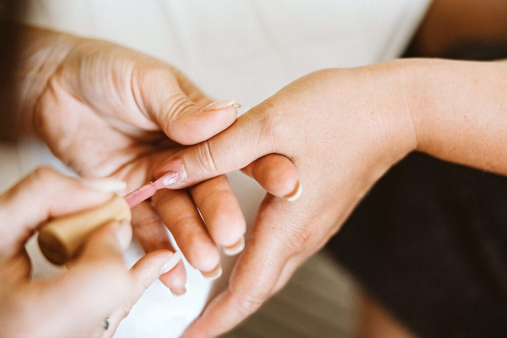 Schlosskapelle Diersfordt Wesel Schloss Diersfordt Wesel Hochzeitsfotograf - Braut bekommt rosa Nagellack von Trauzeugin aufgetragen