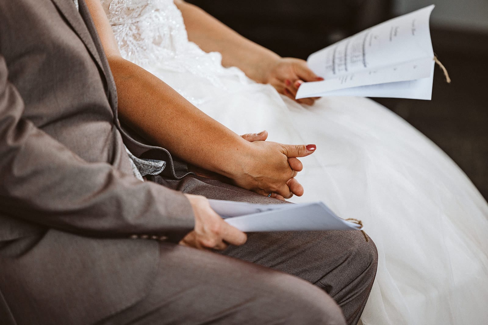 Schlosskapelle Diersfordt Wesel Schloss Diersfordt Wesel Hochzeitsfotograf - Brautpaar hält Händchen und Liedtext für Zeremonie