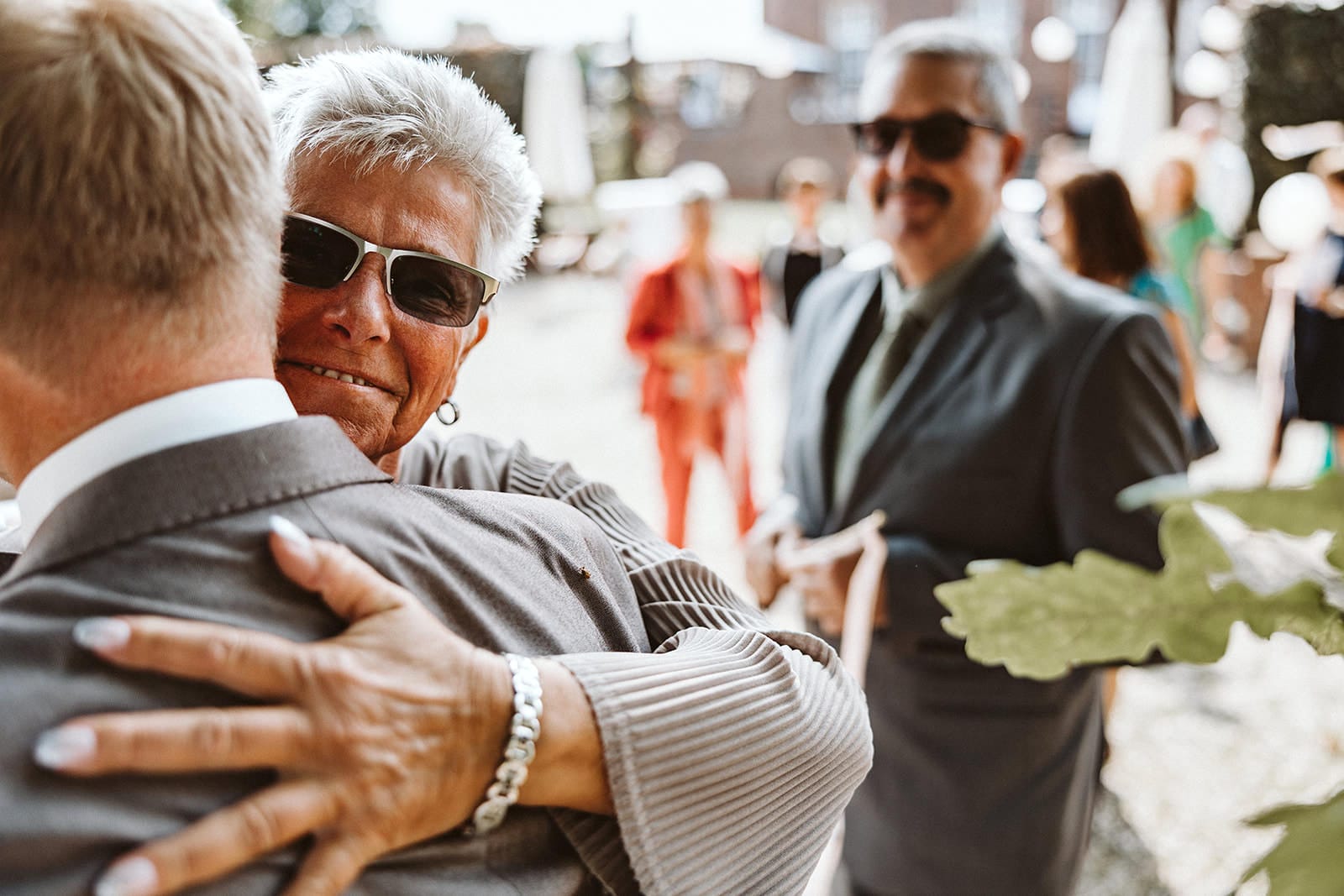 Schlosskapelle Diersfordt Wesel Schloss Diersfordt Wesel Hochzeitsfotograf - Weiblicher Hochzeitsgast umarmt Trauzeuge zur Gratulation
