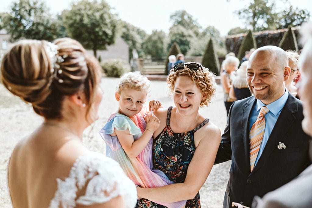 Schlosskapelle Diersfordt Wesel Schloss Diersfordt Wesel Hochzeitsfotograf - Hochzeitsgast mit Kind gratuliert Braut
