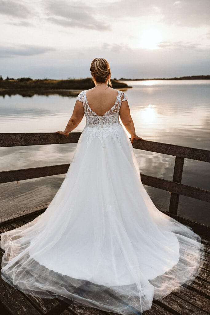 Schlosskapelle Diersfordt Wesel Schloss Diersfordt Wesel Hochzeitsfotograf - Braut auf einem Holzsteg schaut zum Sonnenuntergang in Richtung See