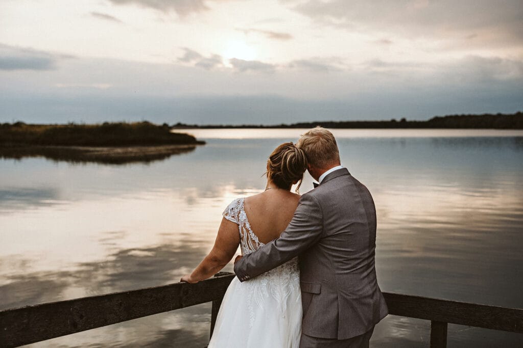 Schlosskapelle Diersfordt Wesel Schloss Diersfordt Wesel Hochzeitsfotograf - Braut und Bräutigam genießen Stille am See auf einem Holzsteg