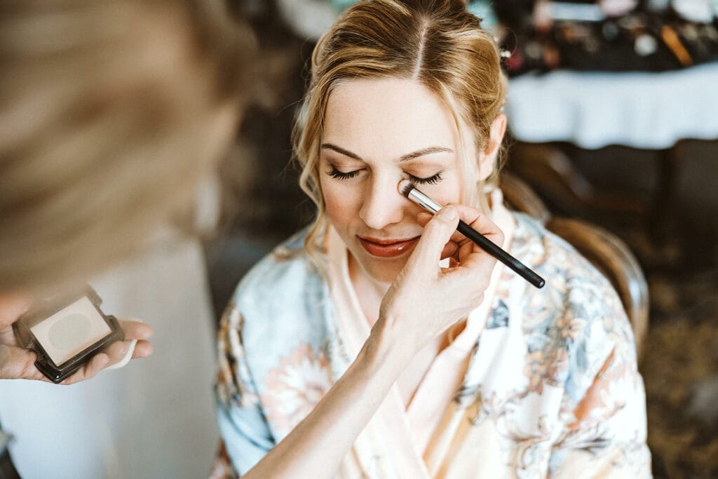 St. Mariä Empfängnis Essen Hochzeitsfotograf - Braut bekommt beim Getting Ready den letzten Pinselstrich