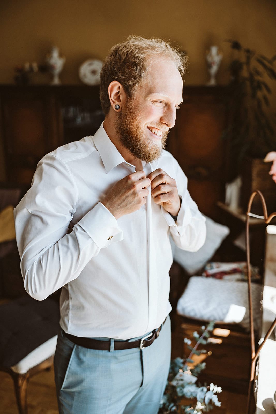 St. Mariä Empfängnis Essen Hochzeitsfotograf - Bräutigam knüpft sich zum Getting Ready Hemd zu