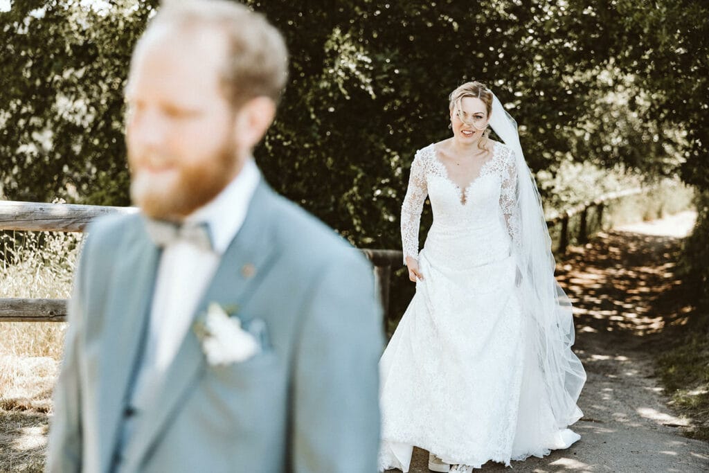 St. Mariä Empfängnis Essen Hochzeitsfotograf - Braut schleicht sich von hinten an Bräutigam First Look