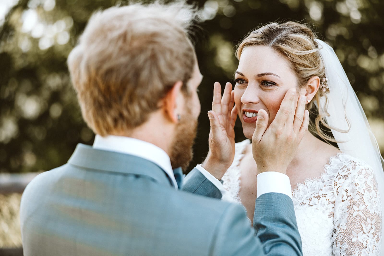St. Mariä Empfängnis Essen Hochzeitsfotograf - Bräutigam trocknet Tränen der Braut beim First Look