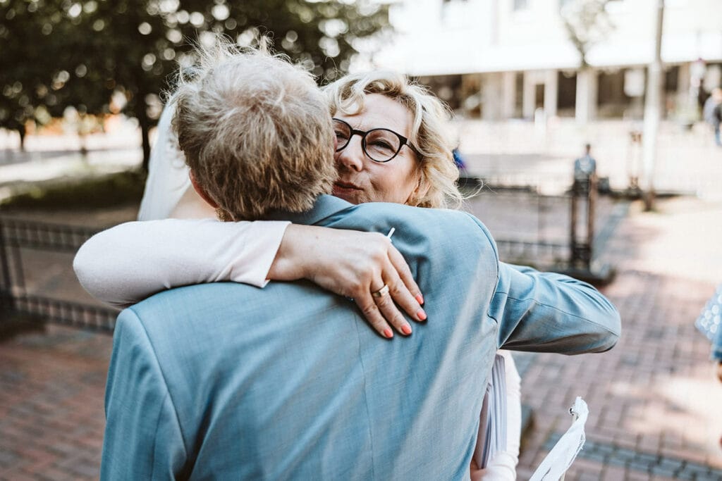 St. Mariä Empfängnis Essen Hochzeitsfotograf - Brautmutter umarmt Bräutigam