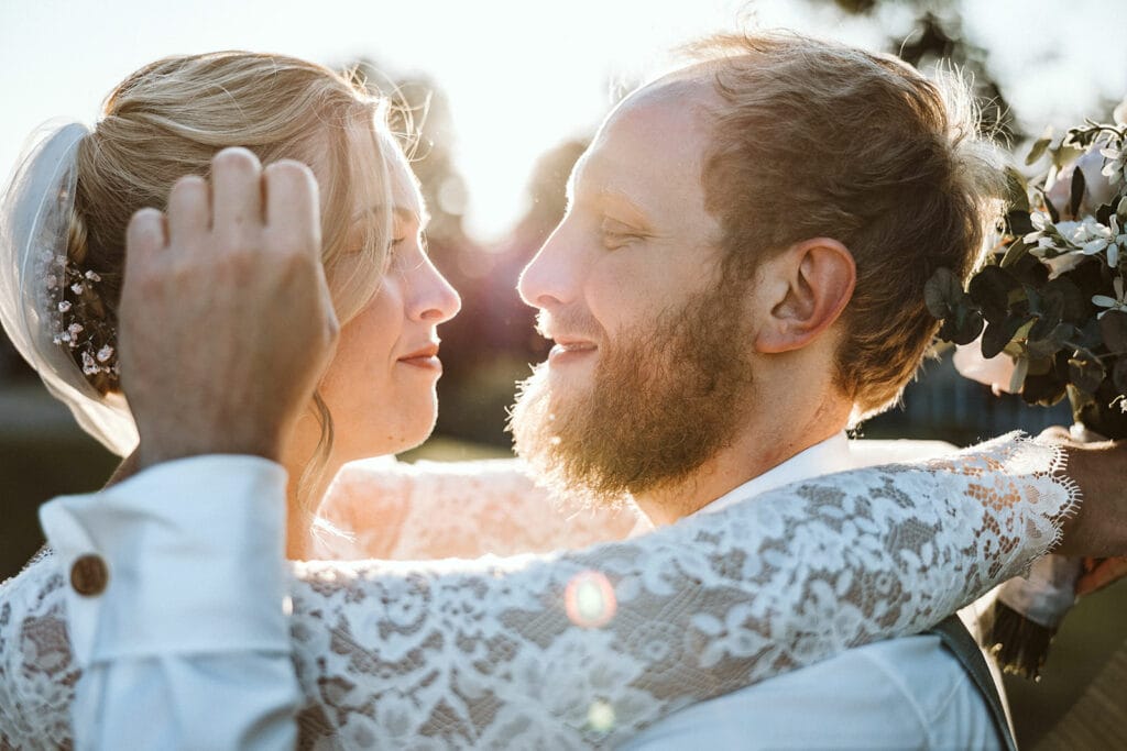 St. Mariä Empfängnis Essen Hochzeitsfotograf - Bräutigam streichelt Braut durchs Haar bei Sonnenuntergang