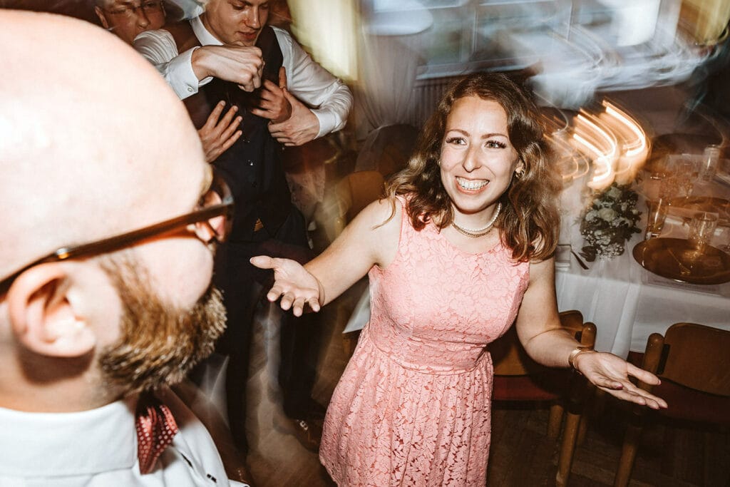 St. Mariä Empfängnis Essen Hochzeitsfotograf - Frau Hochzeitsgast im pinken Kleid feiert Hochzeitsparty