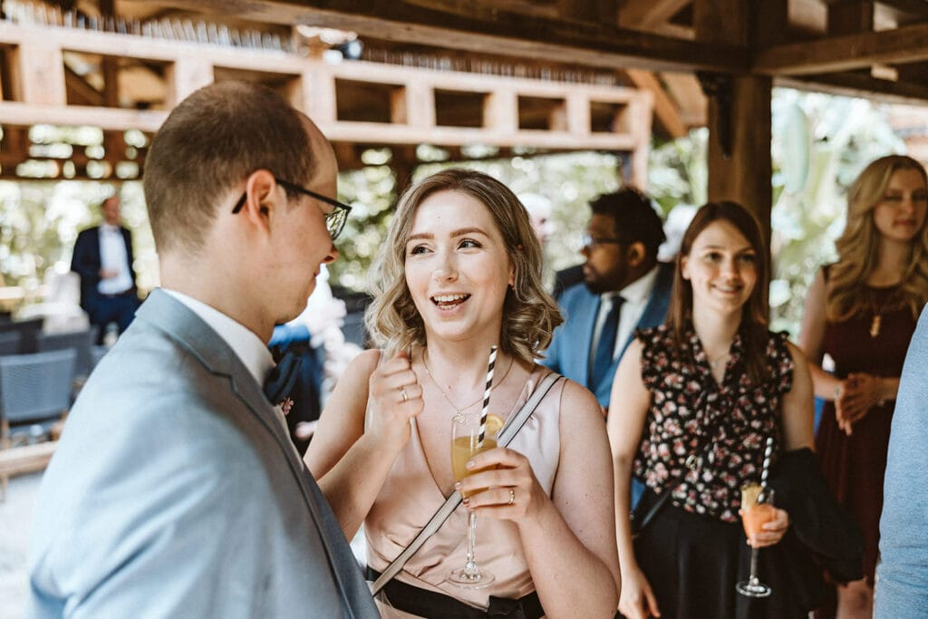 ZOOM Erlebniswelt Gelsenkirchen Ryokan Gelsenkirchen Hochzeitsfotograf - Trauzeugin spricht mit Bräutigam Sektempfang