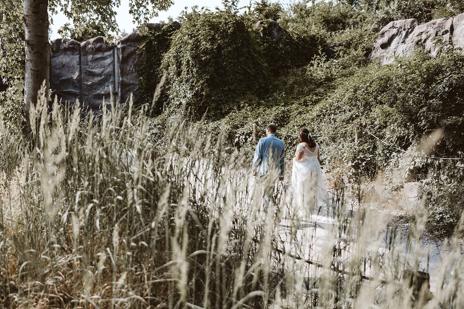 ZOOM Erlebniswelt Gelsenkirchen Ryokan Gelsenkirchen Hochzeitsfotograf - Braut und Bräutigam spazieren entlang eines Feldes