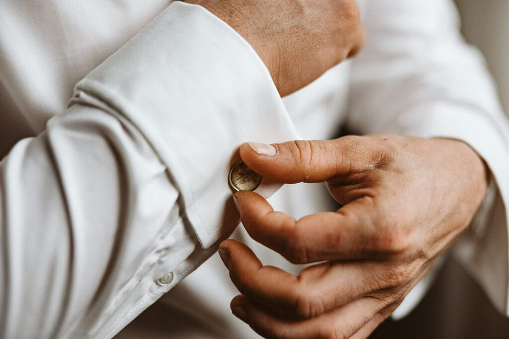 Die Farm Essen die Straußenfarm Essen Hochzeitsfotograf - Bräutigam knöpft seine Ärmel zum Betim Getting Ready