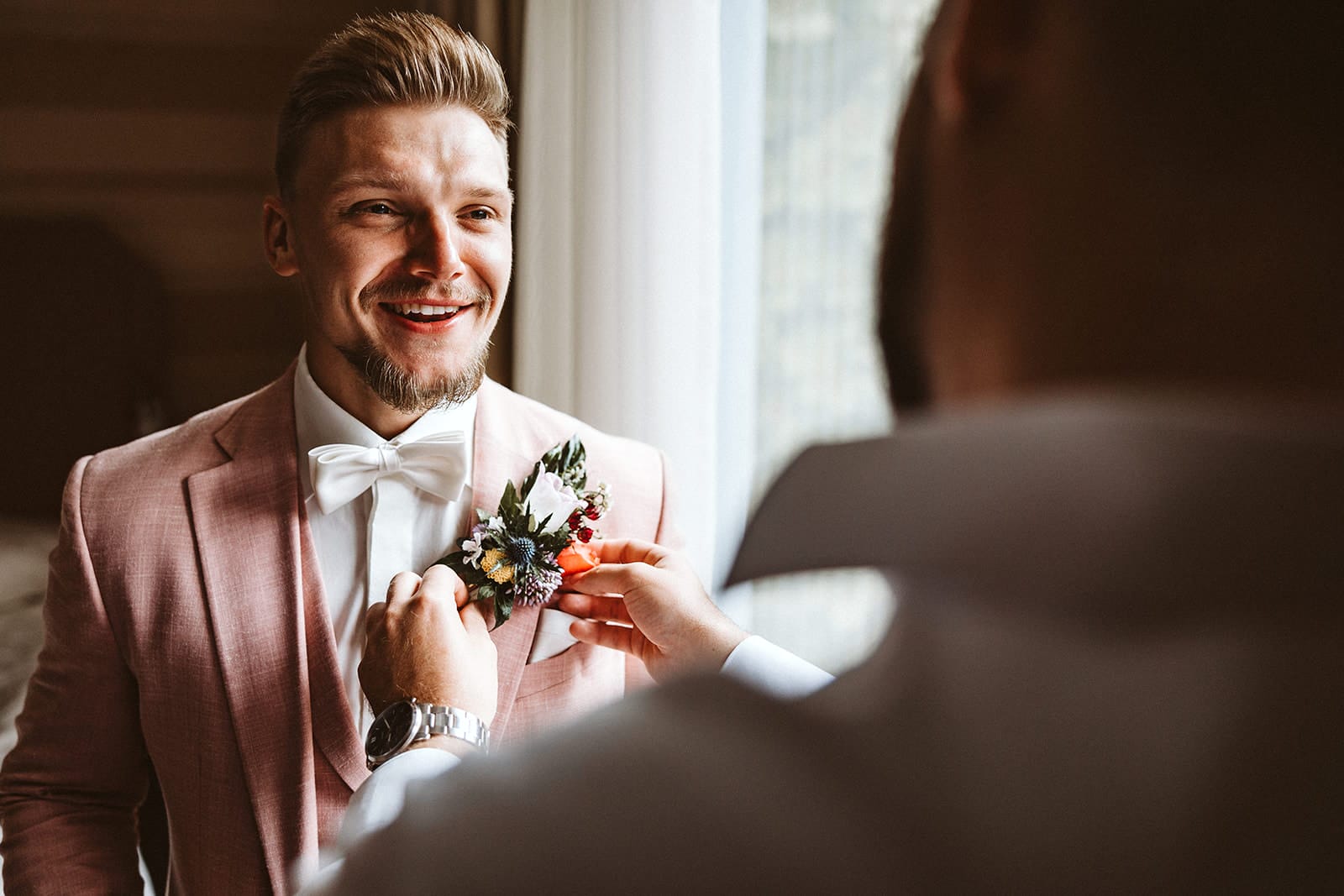 Die Farm Essen die Straußenfarm Essen Hochzeitsfotograf - Trauzeuge kontrolliert Ansteckblumen beim Bräutigam am Sakko