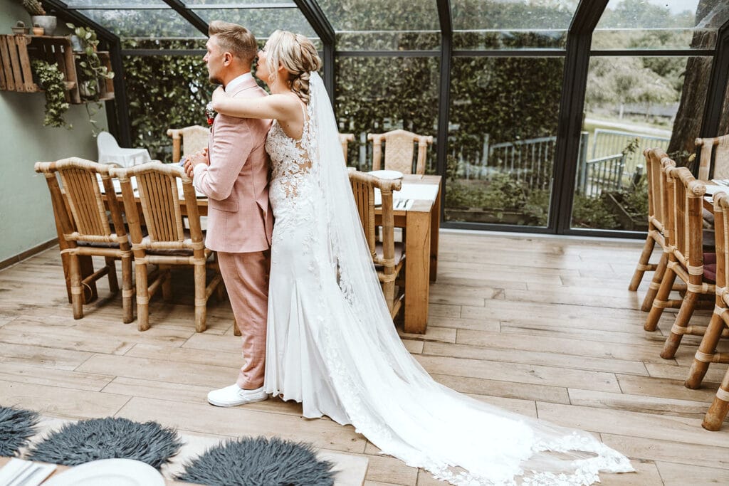 Die Farm Essen die Straußenfarm Essen Hochzeitsfotograf - Braut umarmt Bräutigam von hinten beim First Look