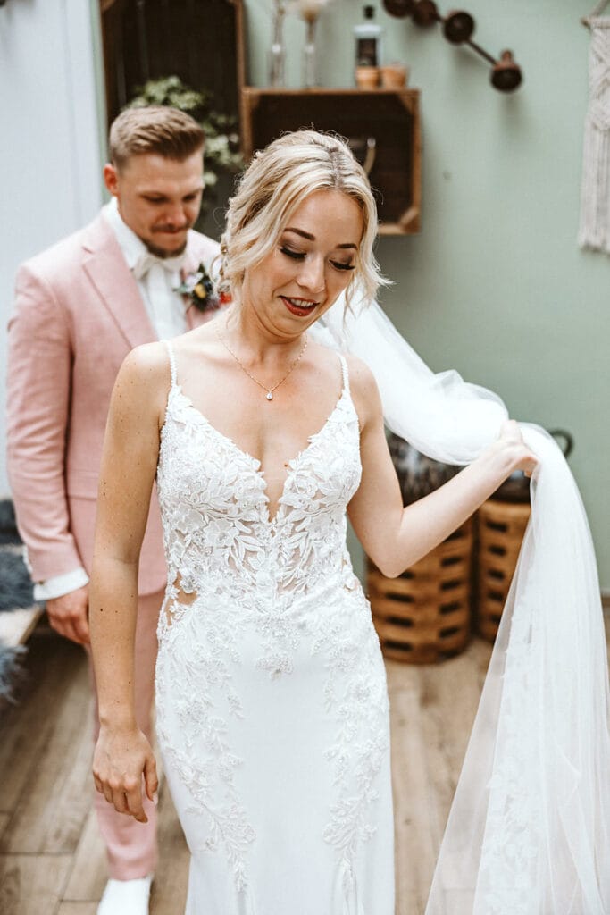 Die Farm Essen die Straußenfarm Essen Hochzeitsfotograf - Braut zeigt Bräutigam neckisch ihr Kleid und ist stolz darauf