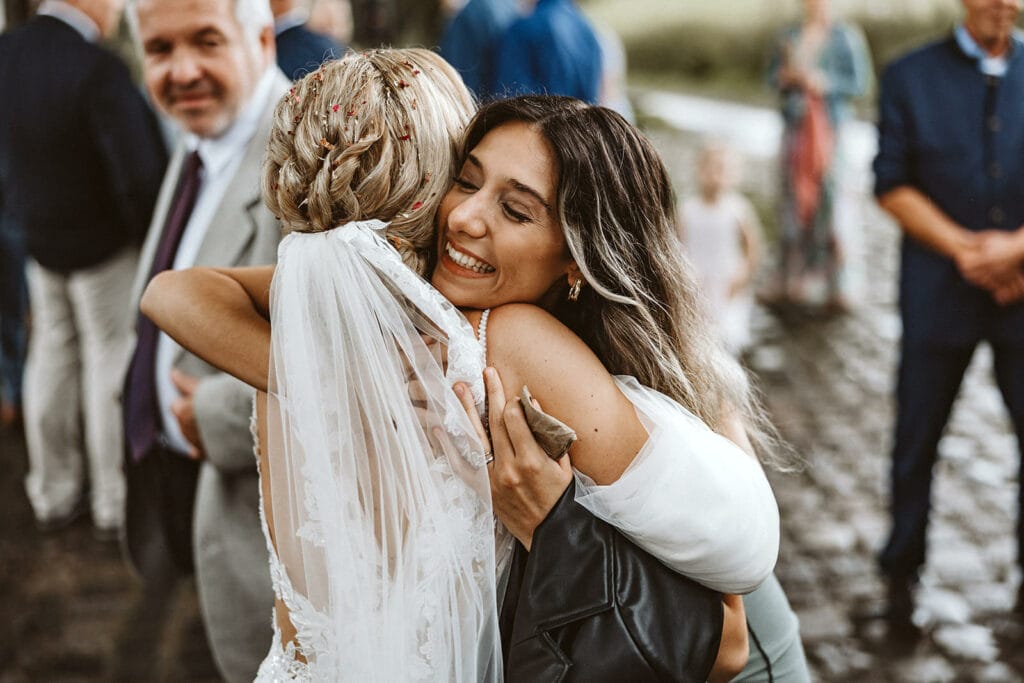 Die Farm Essen die Straußenfarm Essen Hochzeitsfotograf - Hochzeitsgast umarmt Braut herzlich nach Gratulation