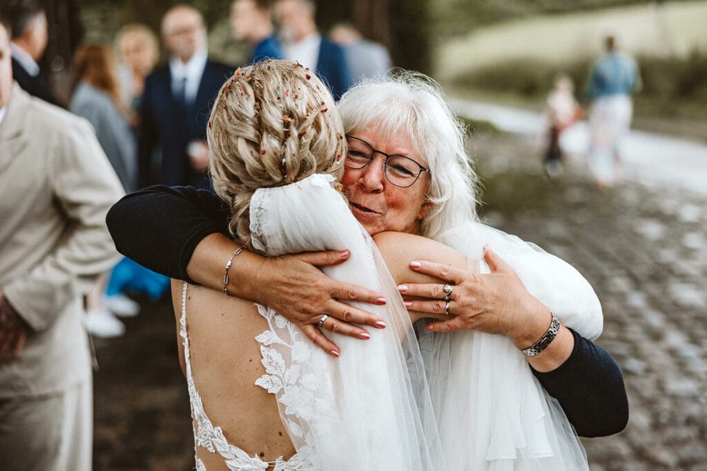Die Farm Essen die Straußenfarm Essen Hochzeitsfotograf - Oma umarmt Braut sehr herzlich und gratuliert ihr zur Hochzeit zur Ehe