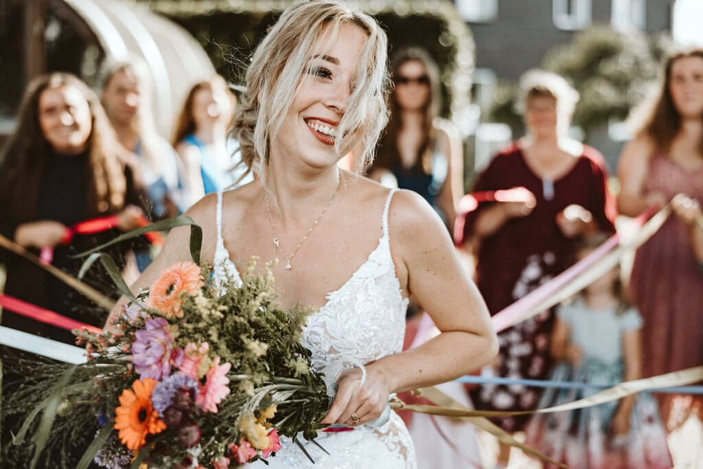 Die Farm Essen die Straußenfarm Essen Hochzeitsfotograf - Braut freut sich über das Hochzeitsspiel mit Brautstraußwurf