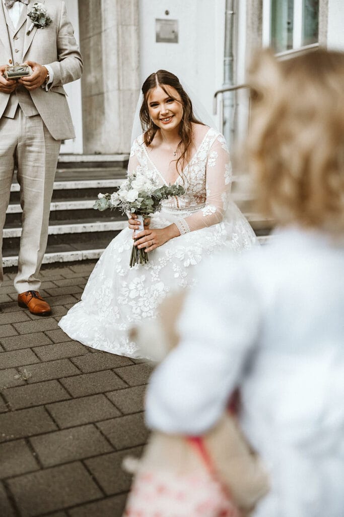 St. Marien Witten Hochzeitsfotograf - Braut kniet sich zu Kind hinunter
