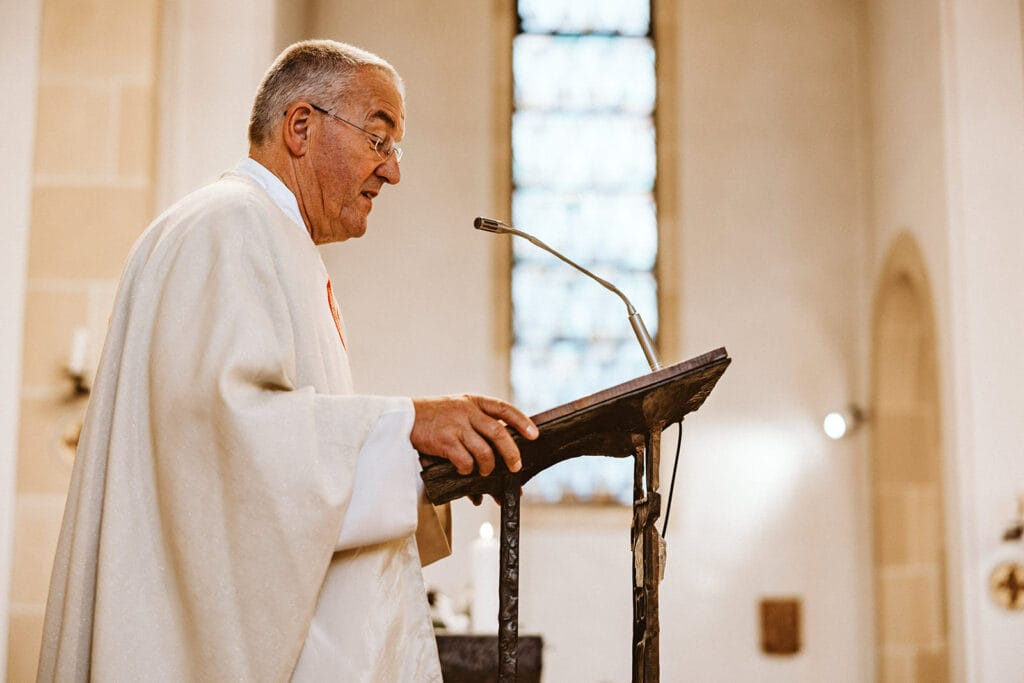 St. Marien Witten Hochzeitsfotograf - Priester singt über Mikrofon Zeremonie