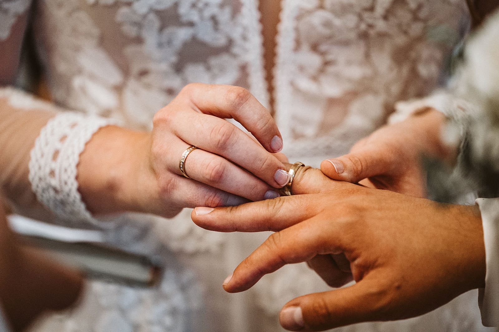 St. Marien Witten Hochzeitsfotograf - Braut stülpt Hochzeitsringe über Ringfinger des Ehemanns