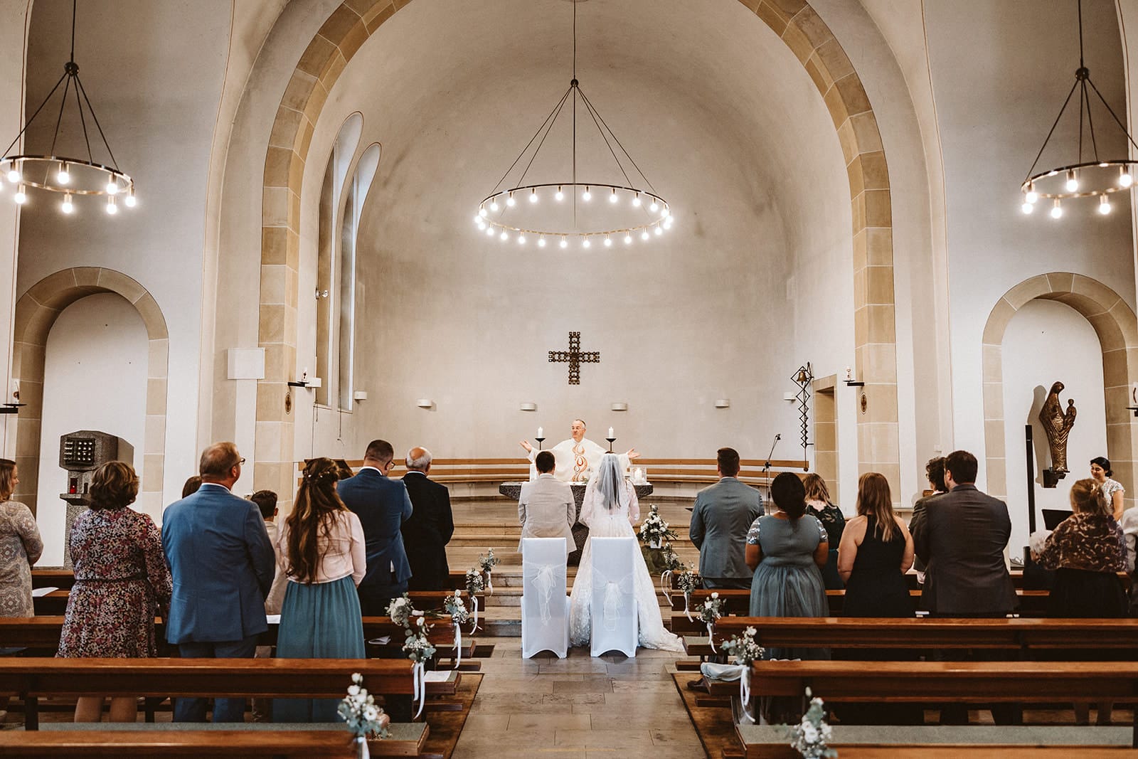 St. Marien Witten Hochzeitsfotograf - Weitwinkel-Aufnahme von Hochzeitspaar in der Kirche und Hochzeitsgesellschaft