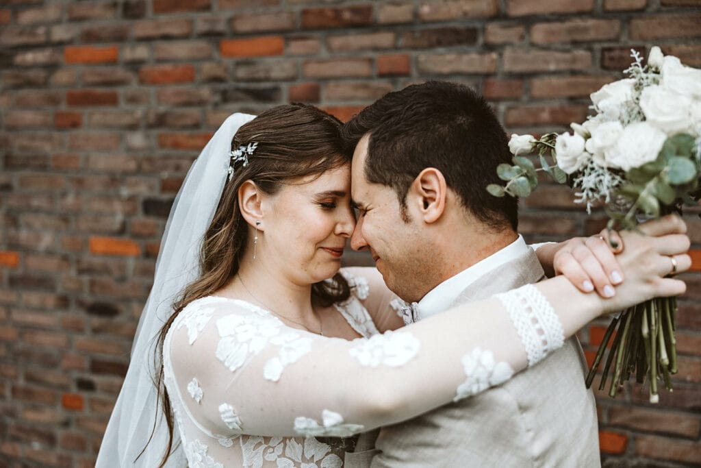 St. Marien Witten Hochzeitsfotograf - Braut und Bräutigam umarmen sich einander