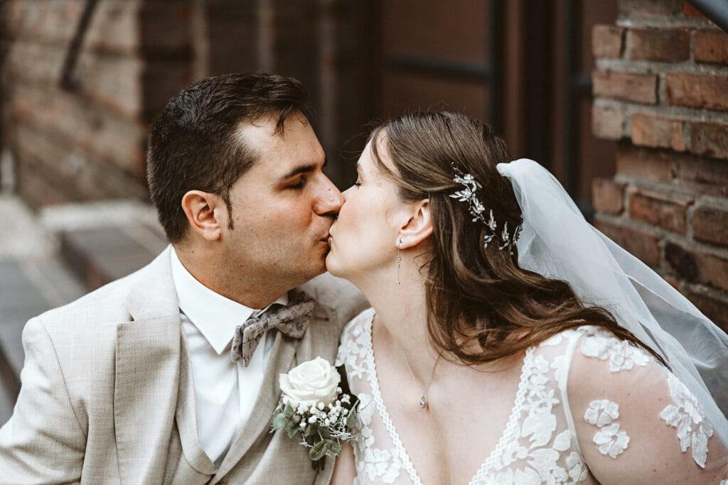 St. Marien Witten Hochzeitsfotograf - Brautpaar küsst sich vor Kirche