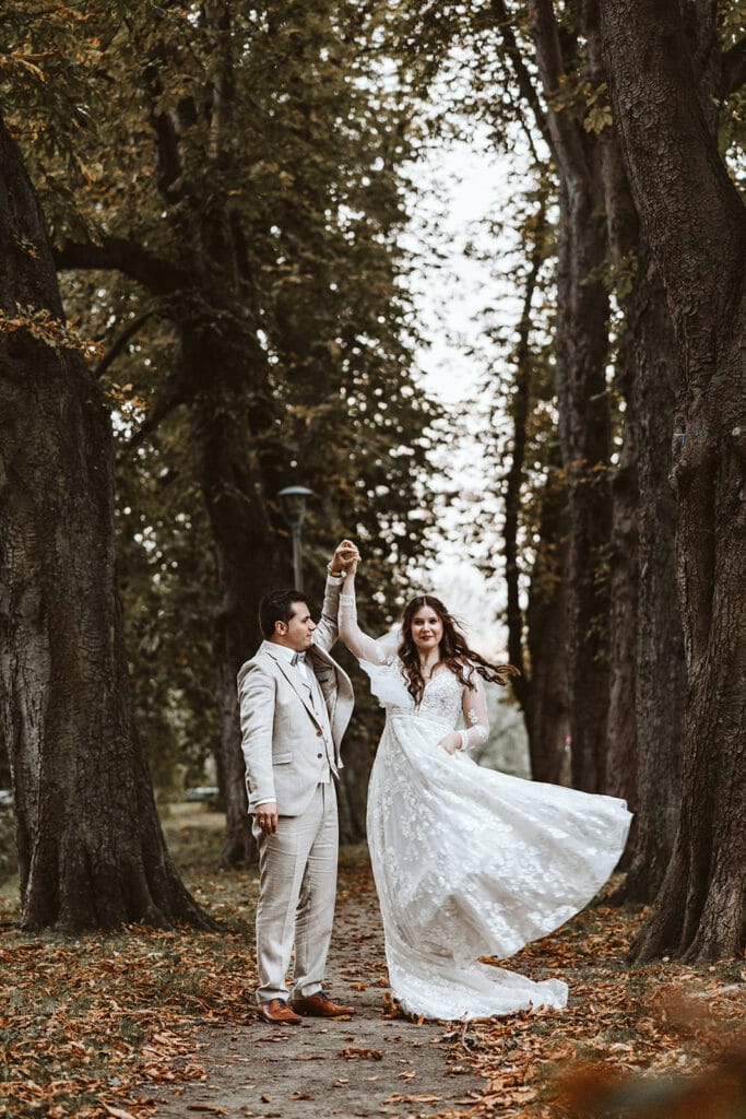 St. Marien Witten Hochzeitsfotograf - Bräutigam dreht sich mit Braut in einer Baumallee
