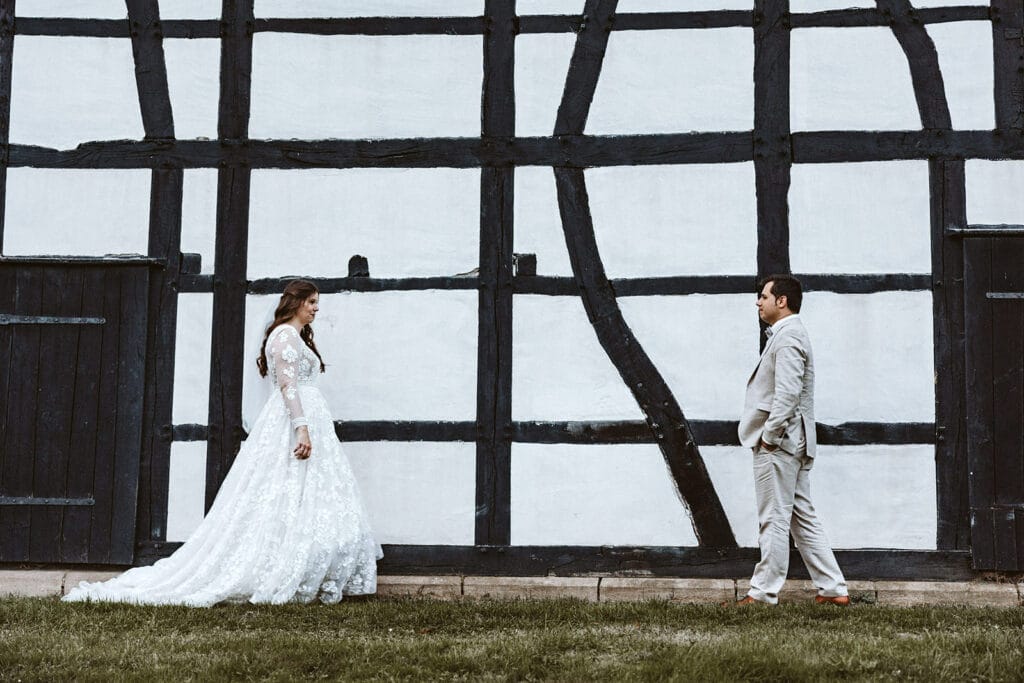 St. Marien Witten Hochzeitsfotograf - Hochzeitspaar geht bei Fachwerkhaus aufeinander zu