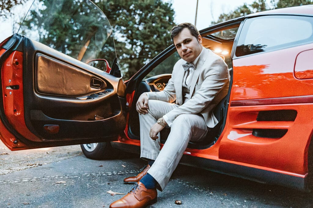 St. Marien Witten Hochzeitsfotograf - Bräutigam schaut aus seinem roten Auto raus